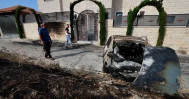 Palestinian residents assess the damage after Israeli settlers attacked the village of Jit