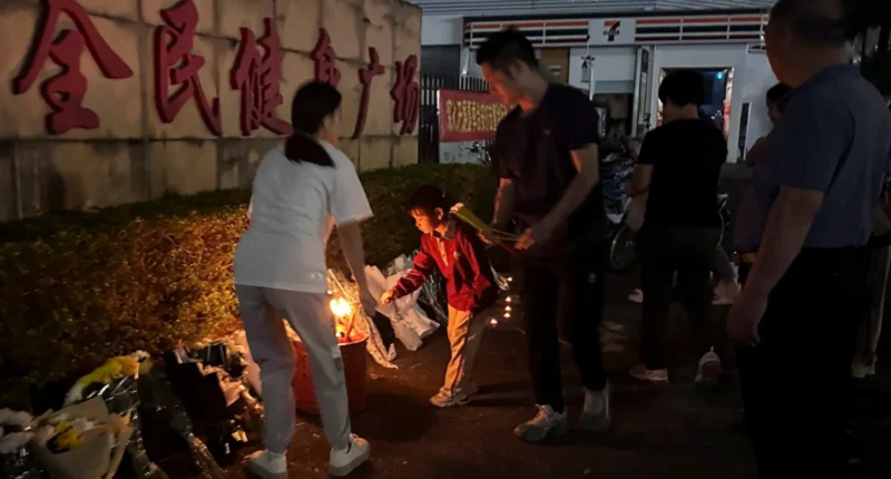 Members of the public burning incense in tribute and placing flowers outside the stadium on Tuesday